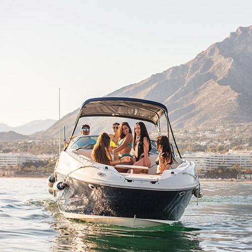 Sea Ray 260 with guests on board, mountains behind